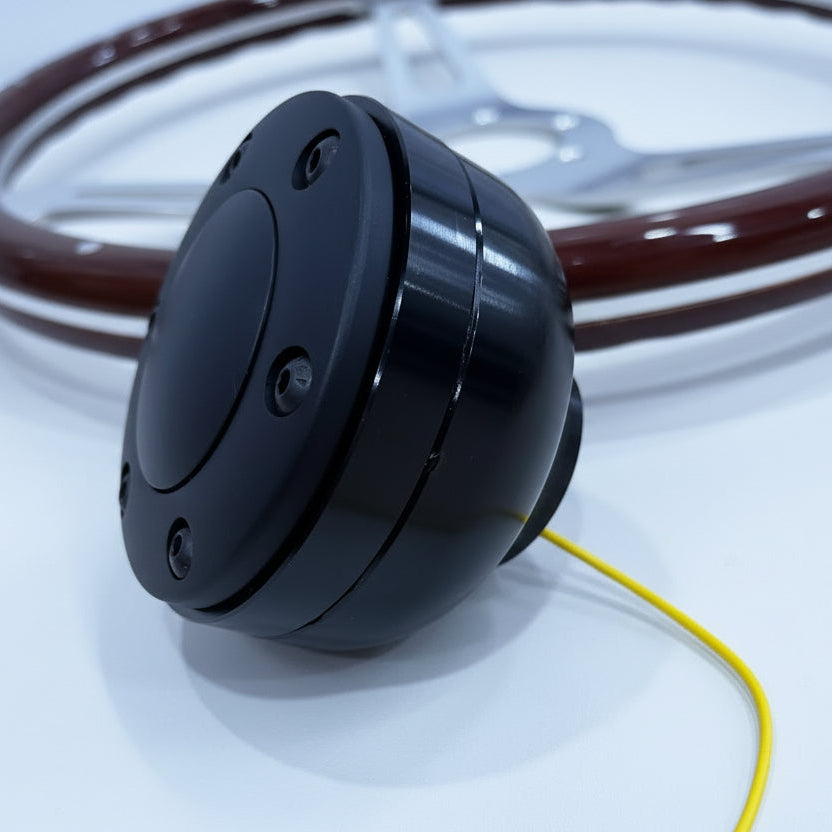 Black electronic component with a yellow wire on a wooden surface