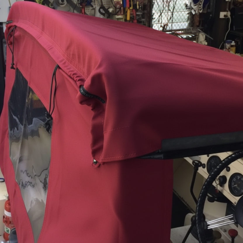 Maroon cover over a vehicle in a workshop setting