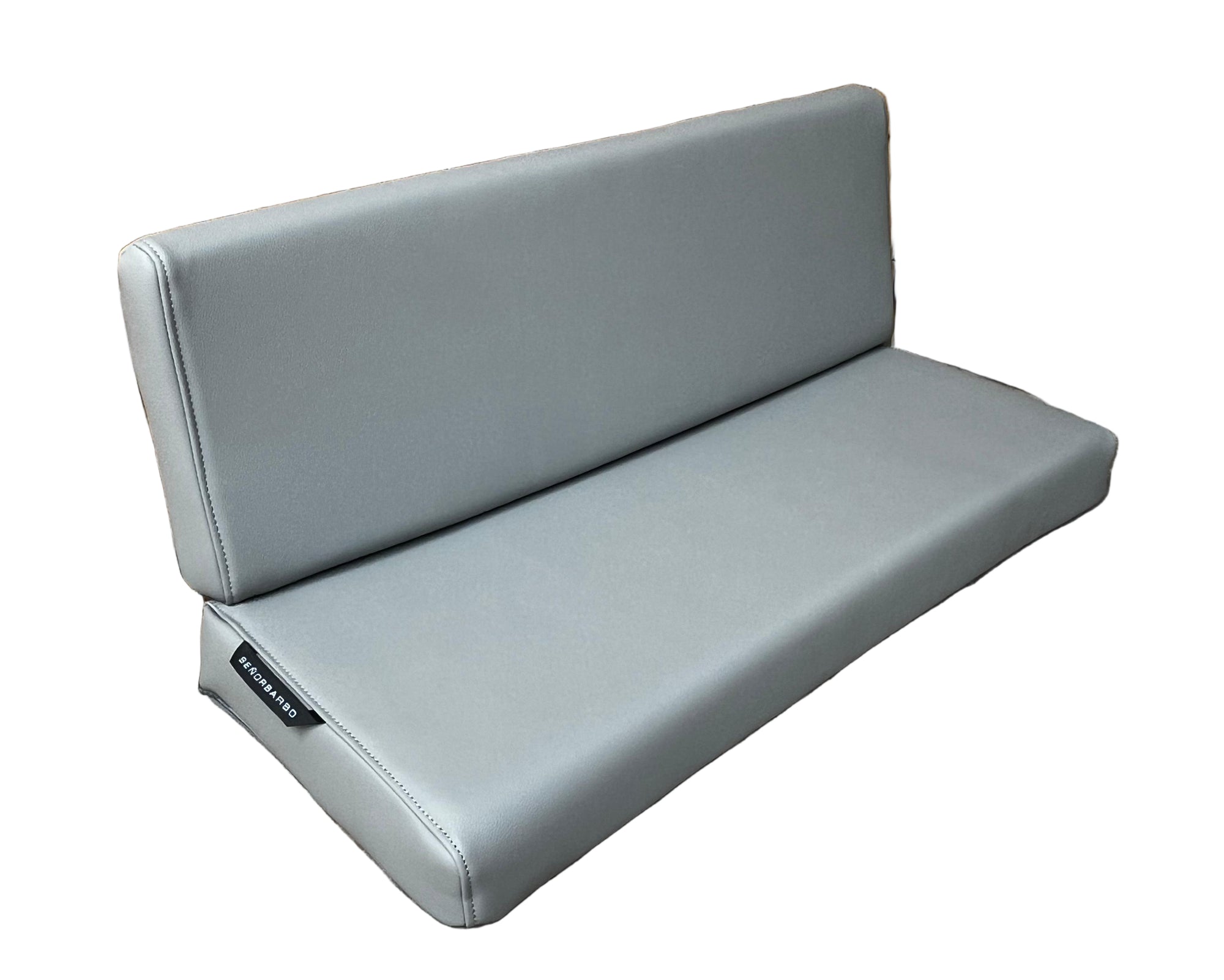 Gray outdoor sofa against a wooden fence on a paved ground