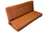 Brown leather bench against a wooden fence on a concrete surface
