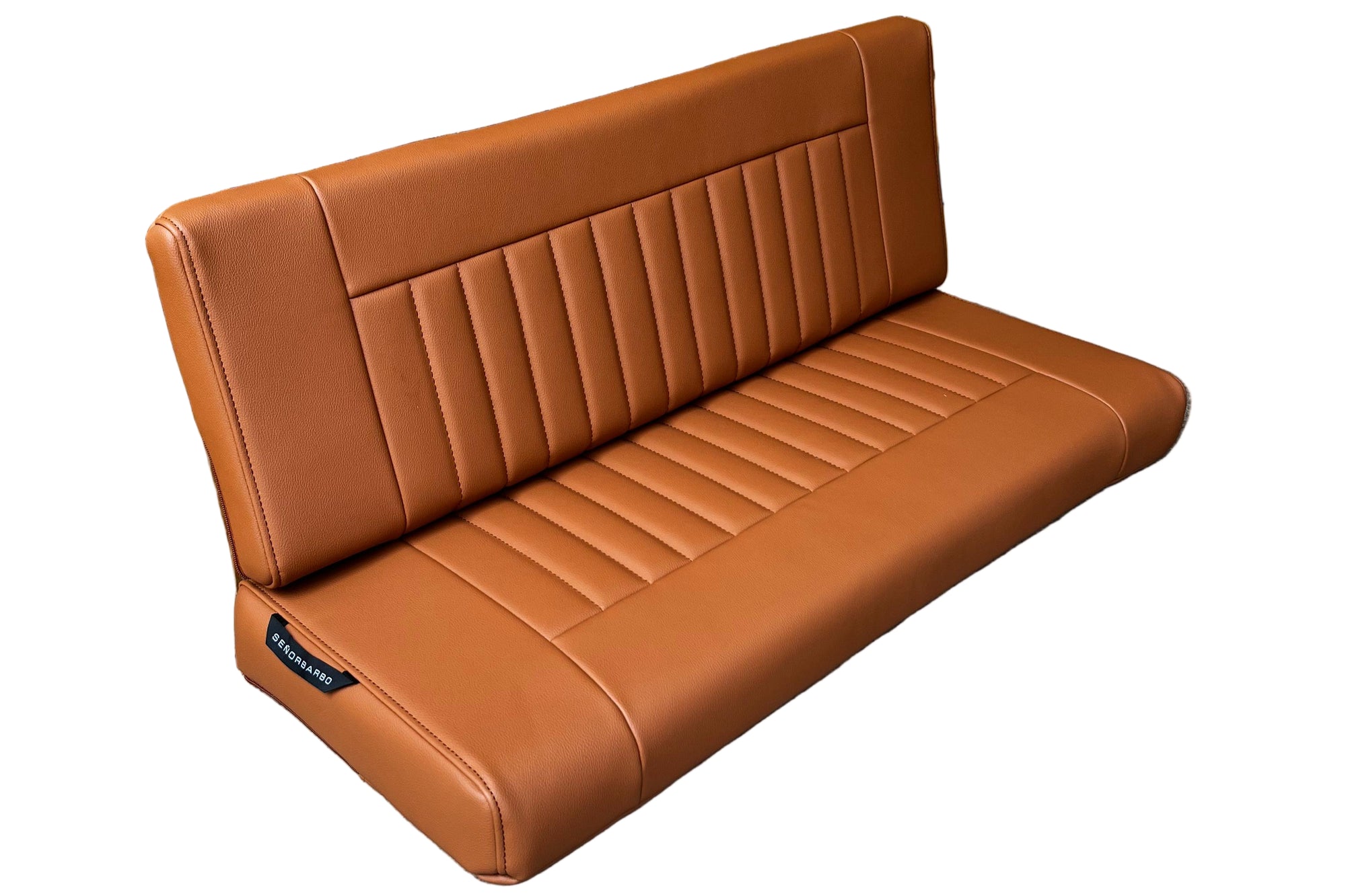 Brown leather bench against a wooden fence on a concrete surface