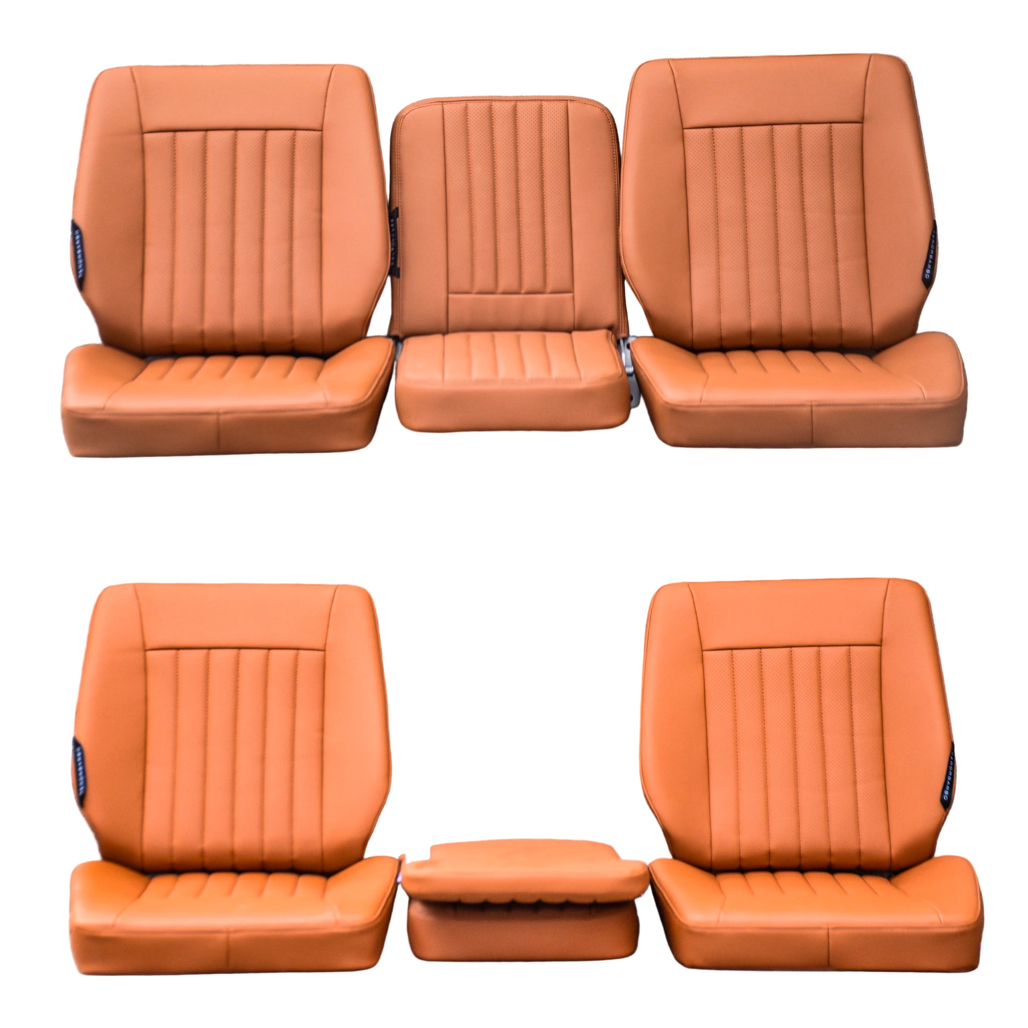 Set of four orange car seat covers arranged against a gray stone wall.