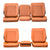 Set of four orange car seat covers arranged against a gray stone wall.