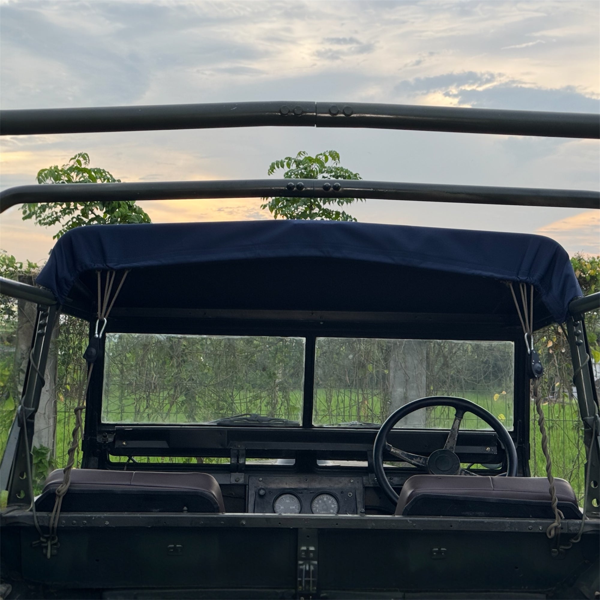 Open-top vehicle with a blue canopy in a natural setting