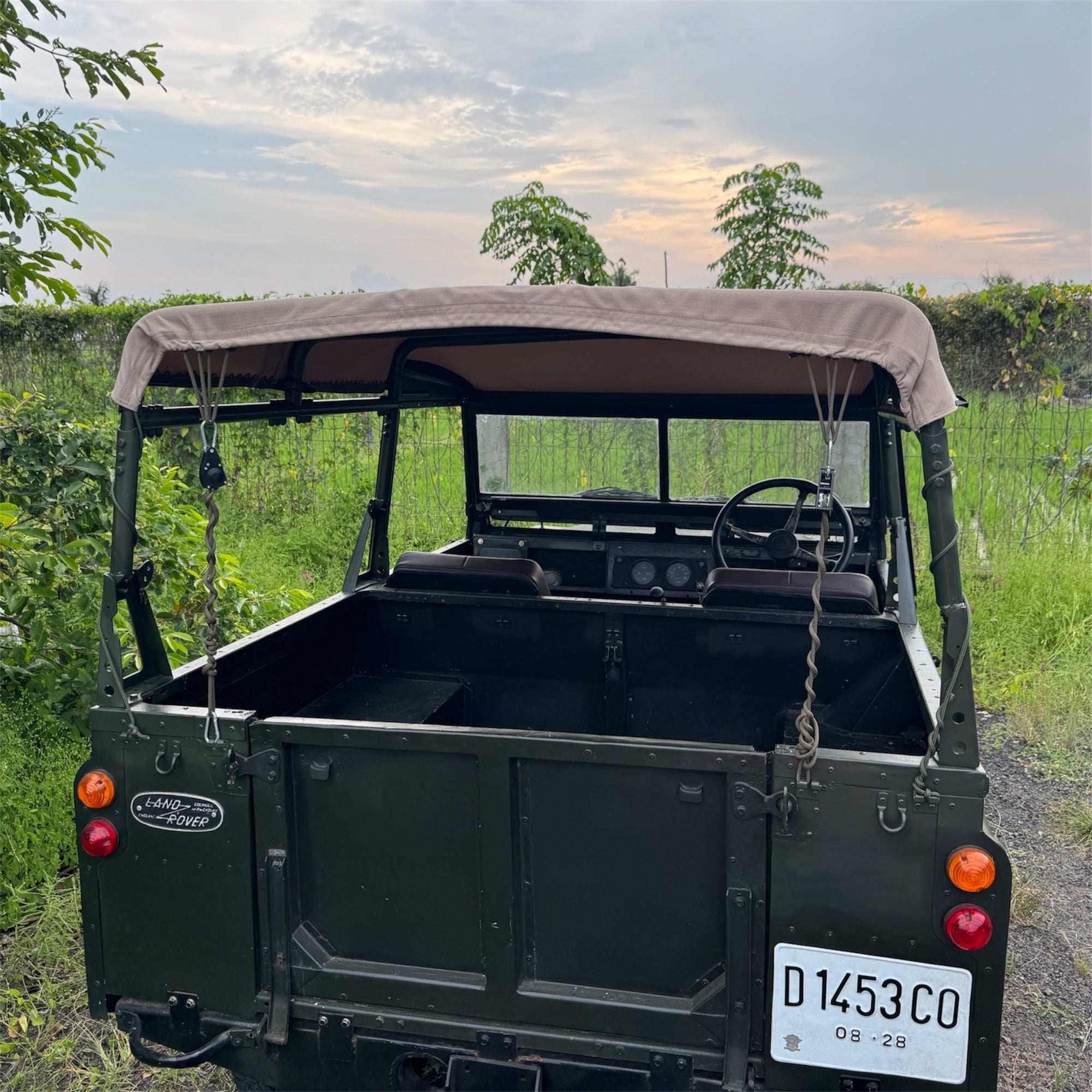 Vintage Land Rover vehicle with an open top in a natural setting