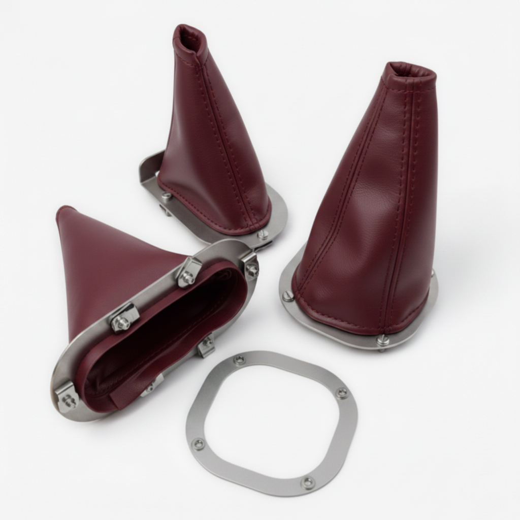 Set of maroon leather gear shift boot covers with metal hardware on a white background
