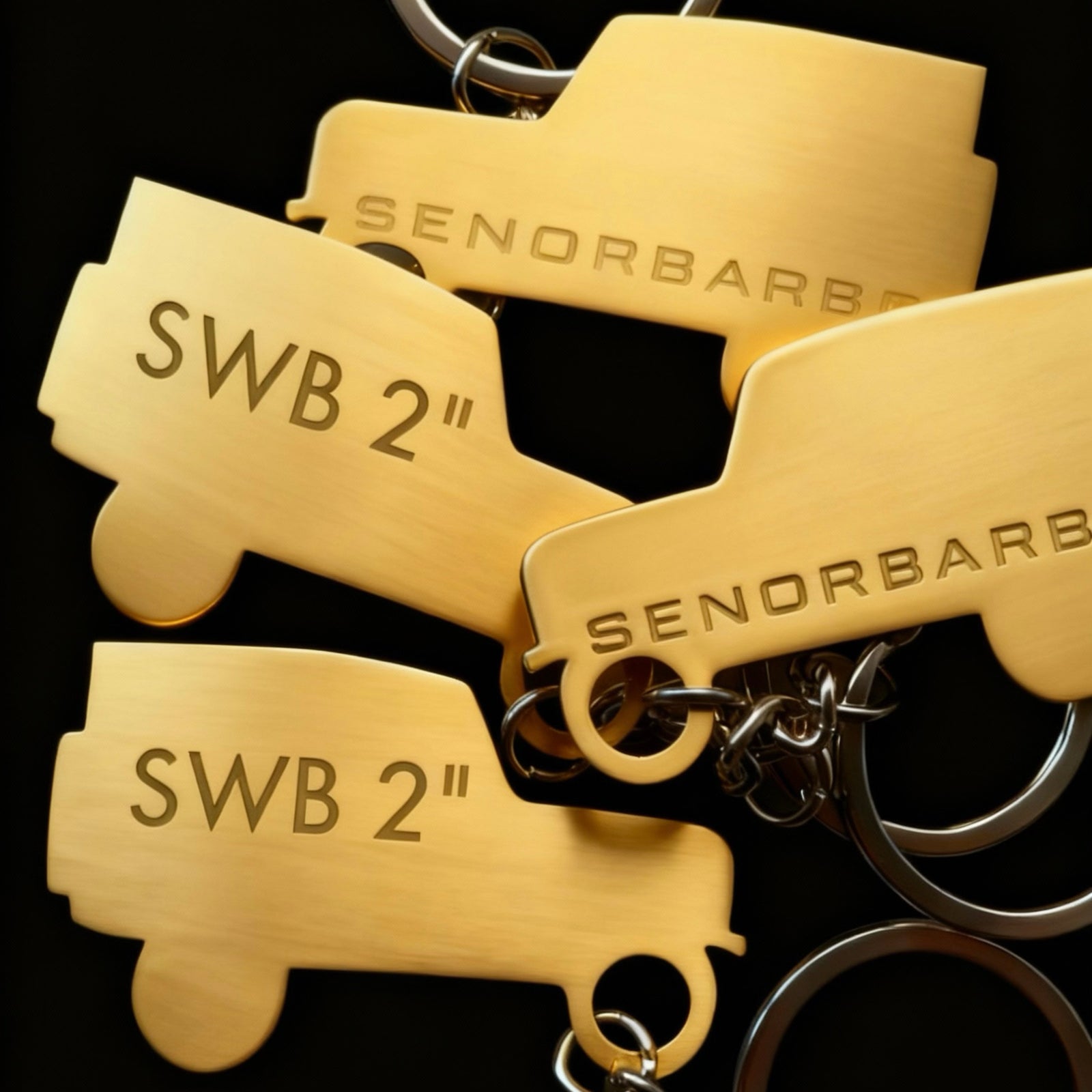 Gold keychains with 'SENORBARBO' branding on a black background